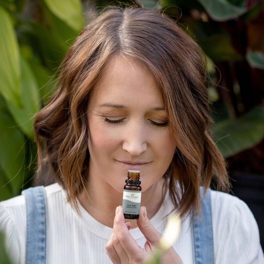 Woman smelling Gut Aid Essential Oil Blend from the bottle