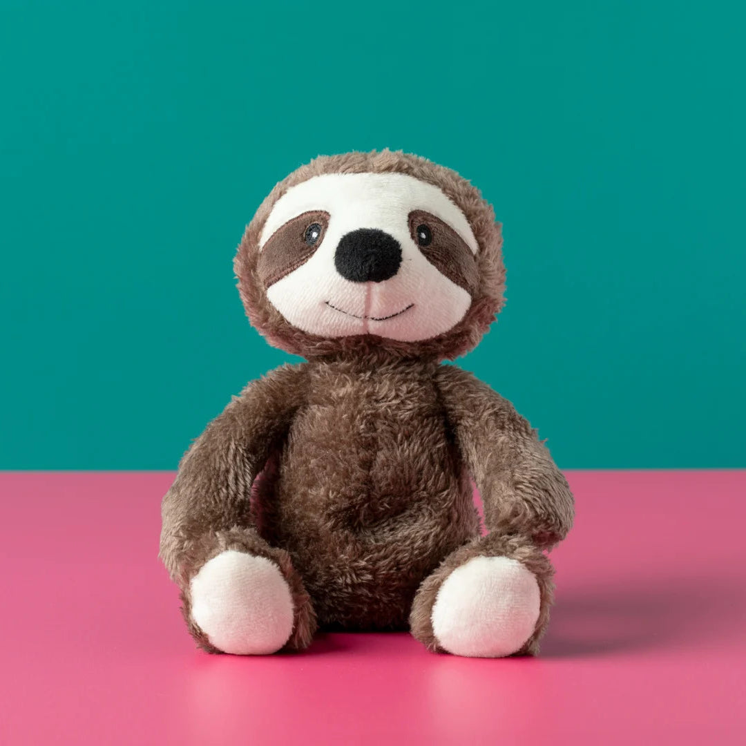 Plush sloth toy on a pink surface with a teal background