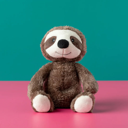 Plush sloth toy on a pink surface with a teal background