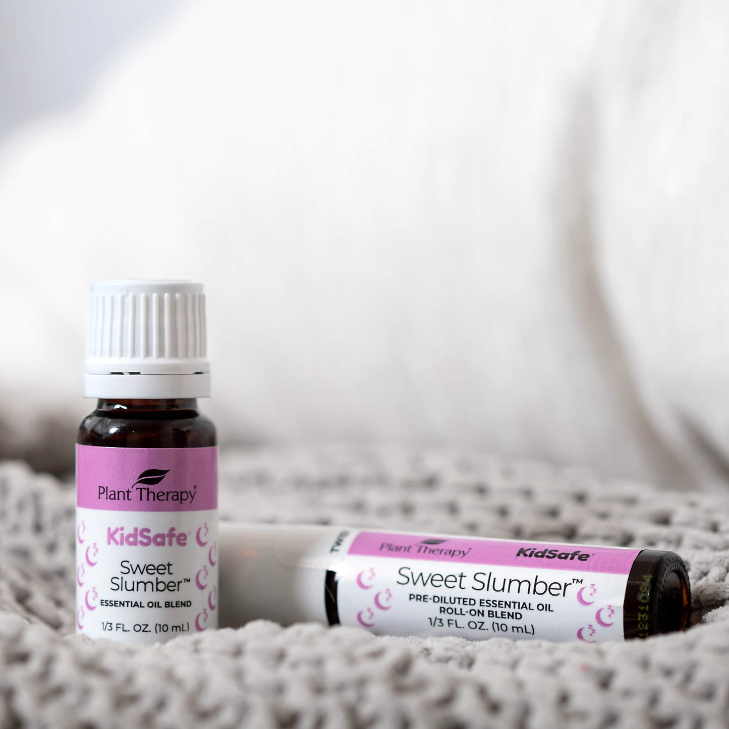 Sweet Slumber KidSafe Essential Oil pictured with matching Prediluted Roll-On on a blanket